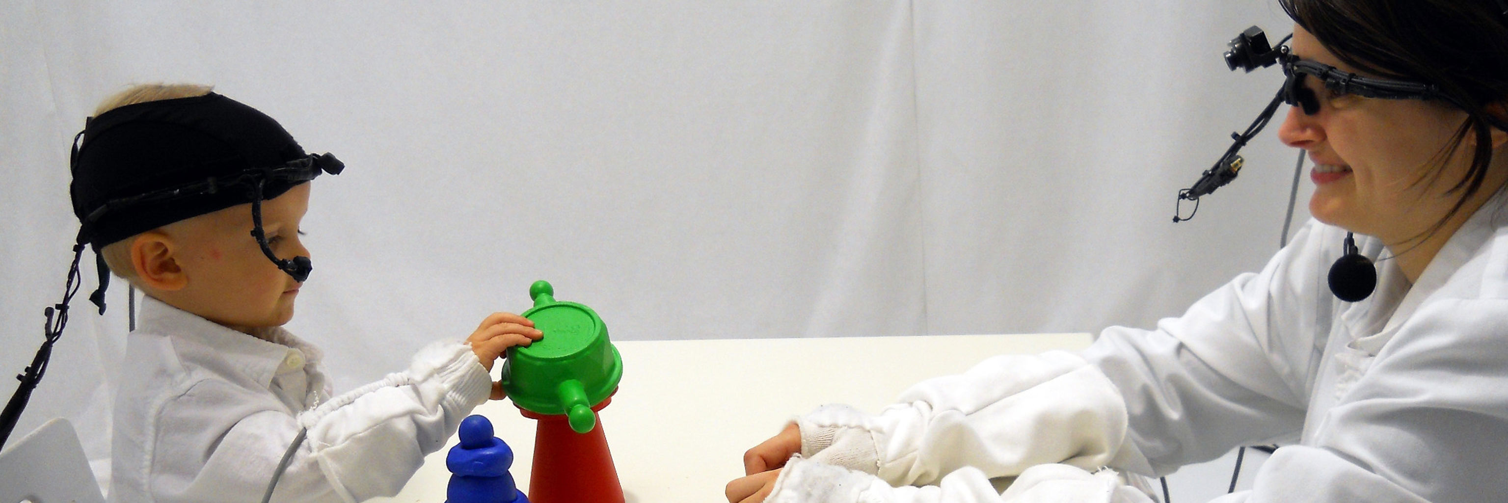 baby and woman playing with toys during an experiment