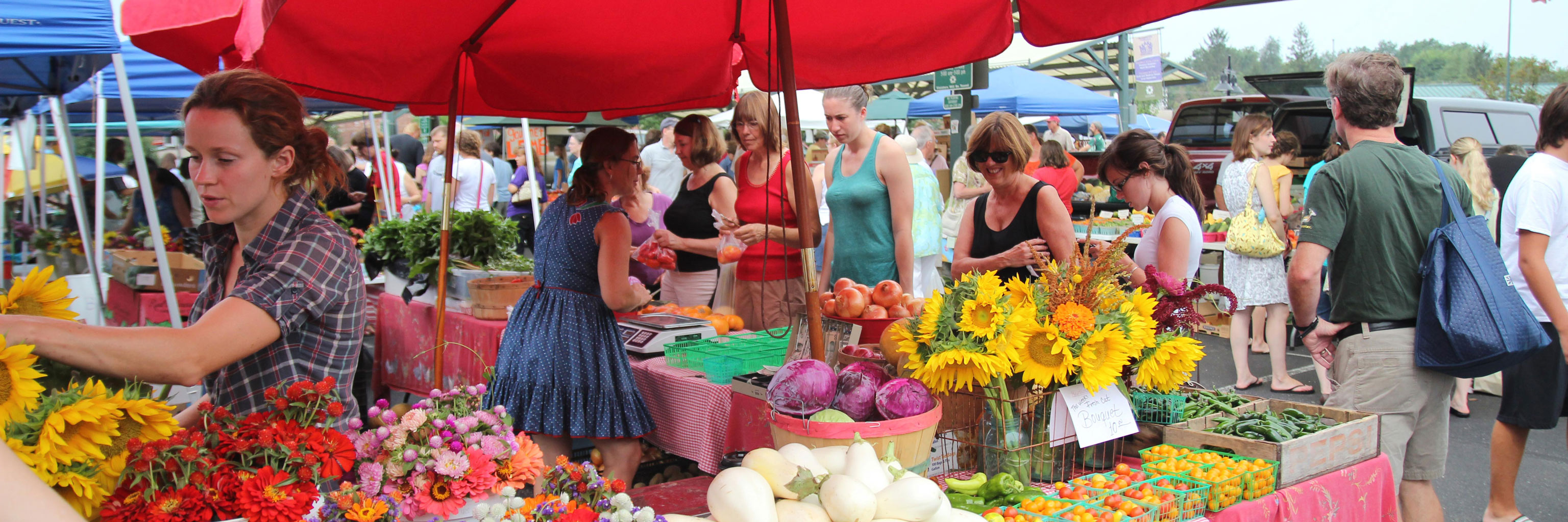 people walking around a farmers market