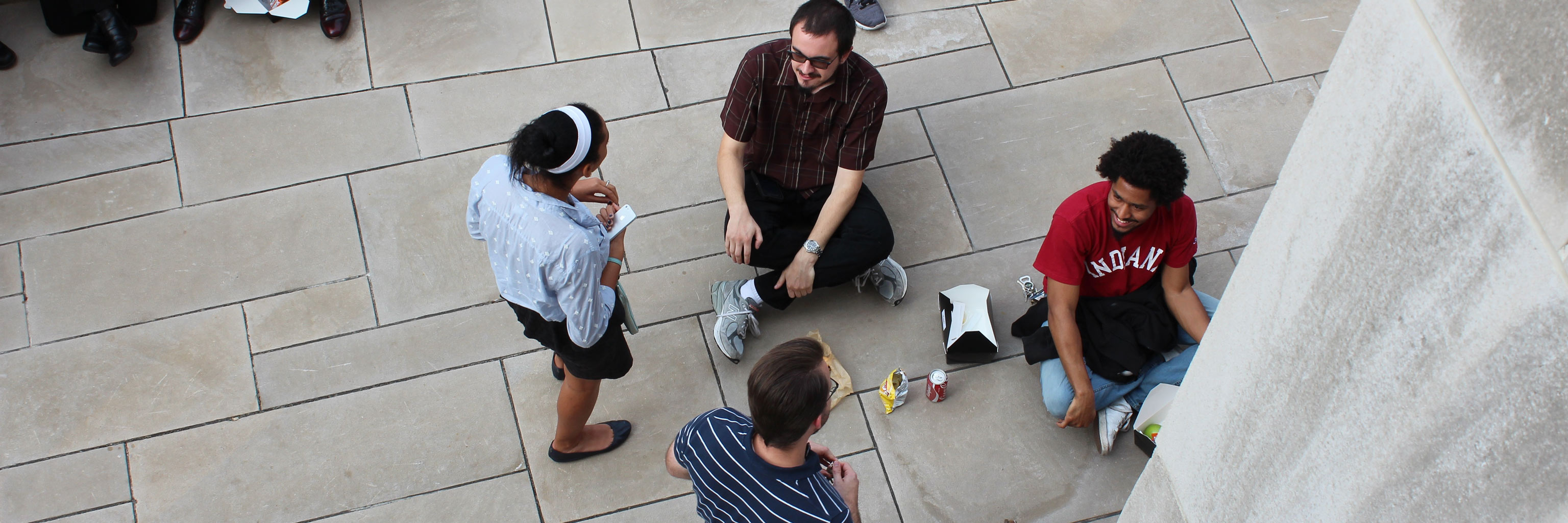 students sitting on the ground outside eating lunch