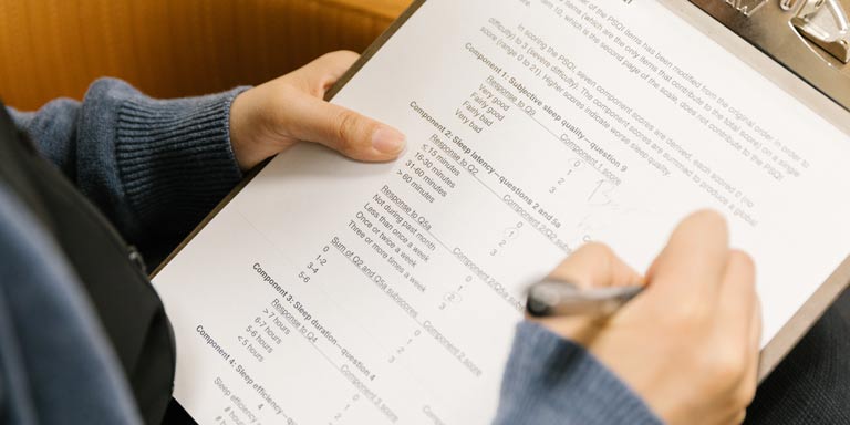 two hands filling out a paper form