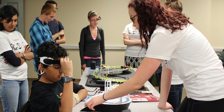 students show children how to move toy cars with their mind