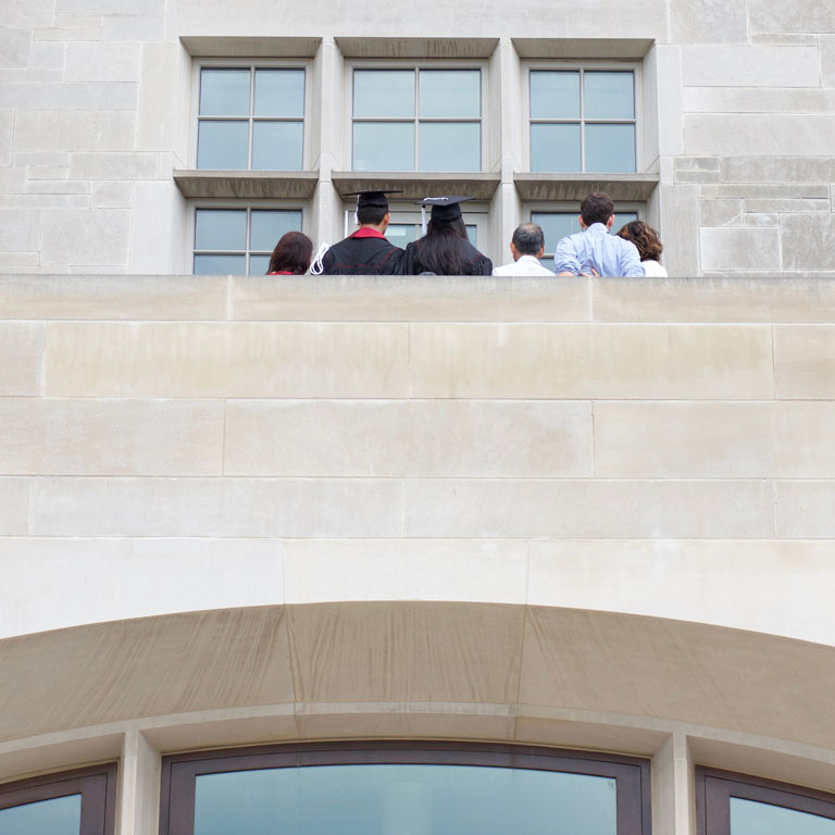 graduated student taking pictures with family on a balcony